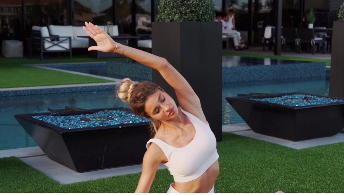Julia in a gentle side stretch during an outdoor practice